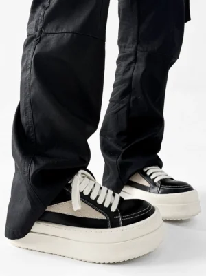 Black low-top platform streetwear sneaker shown from the rear with white laces and thick off-white sole