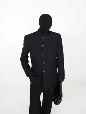 Black Mandarin collar longline blazer styled in an avant-garde all-black streetwear outfit with flared trousers and leather bag front three-quarter view