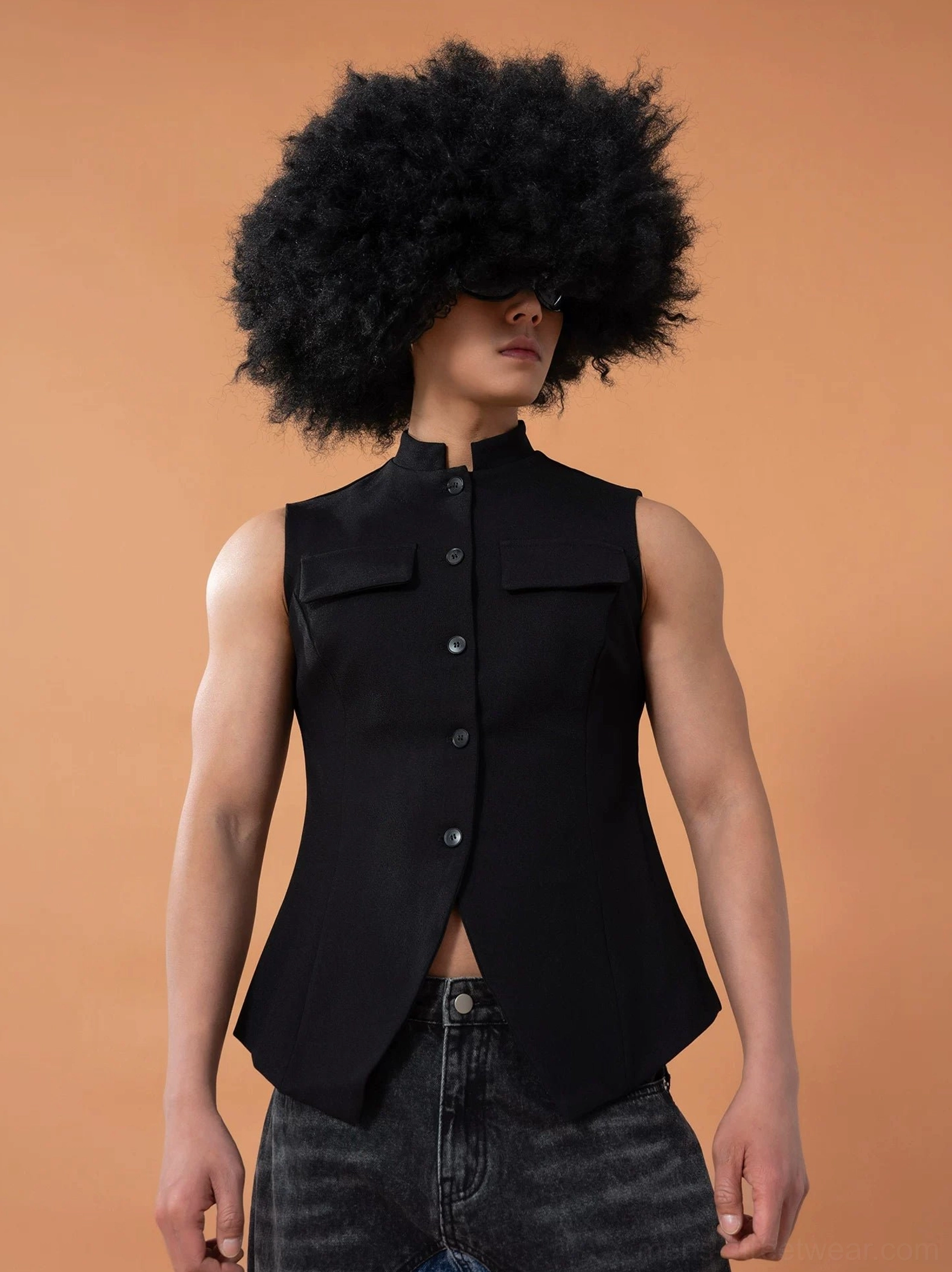 Right front three-quarter view of a black mandarin collar vest highlighting the button placket, chest flap pockets, fitted side shape, and refined tailoring
