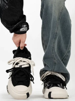 Black marble canvas platform street sneakers with dual-tone laces, rounded toe cap, chunky cream rubber sole, and model wearing loose washed denim