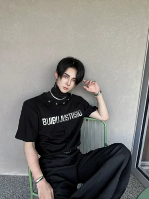 Side three-quarter view of a matte black high-neck streetwear T-shirt with reflective silver lettering and relaxed boxy fit
