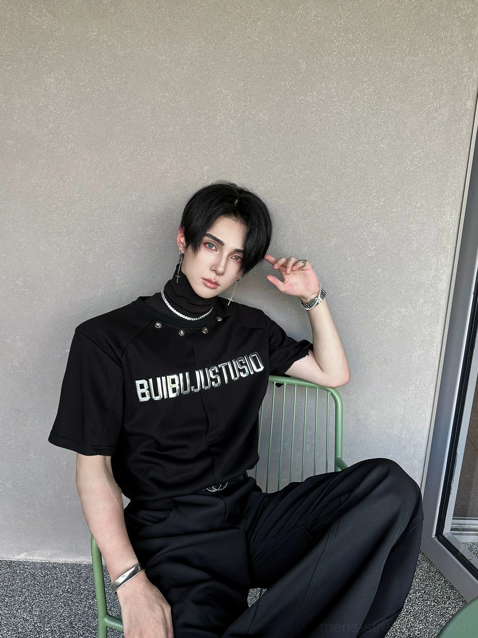 Side three-quarter view of a matte black high-neck streetwear T-shirt with reflective silver lettering and relaxed boxy fit