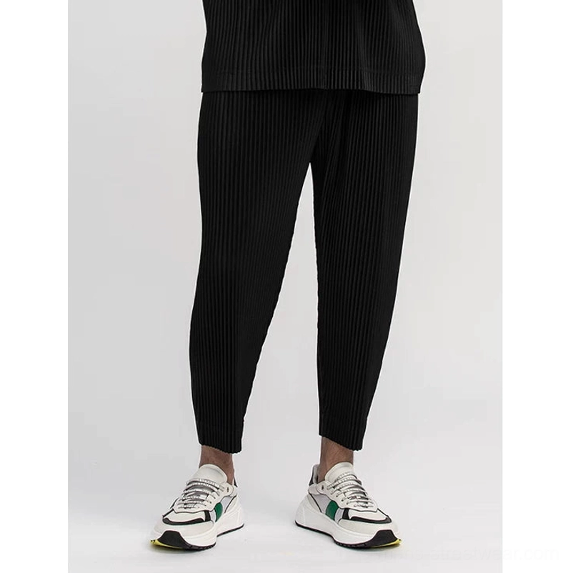 Black men's pleated streetwear outfit featuring a relaxed boxy tee and matching pleated bottoms
