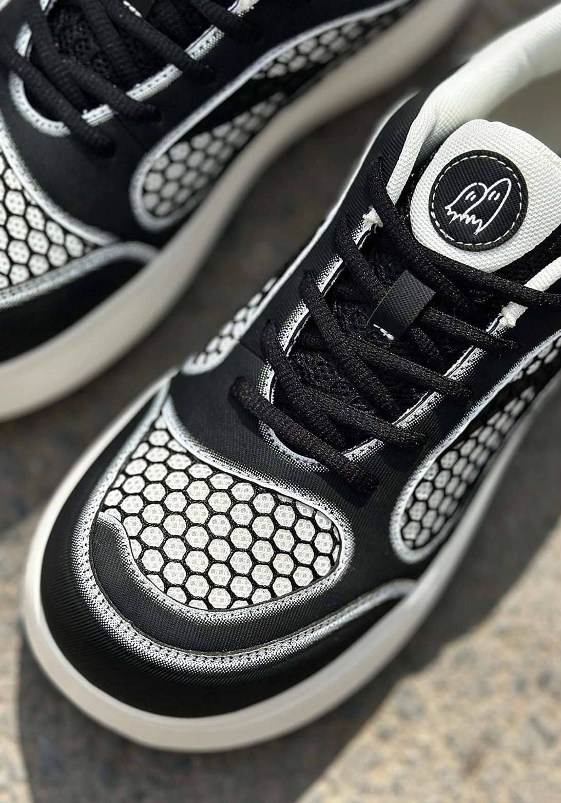 Front top-down view of black mesh platform derby sneakers with lace-up closure, honeycomb toe box, tongue logo, and thick white outsole