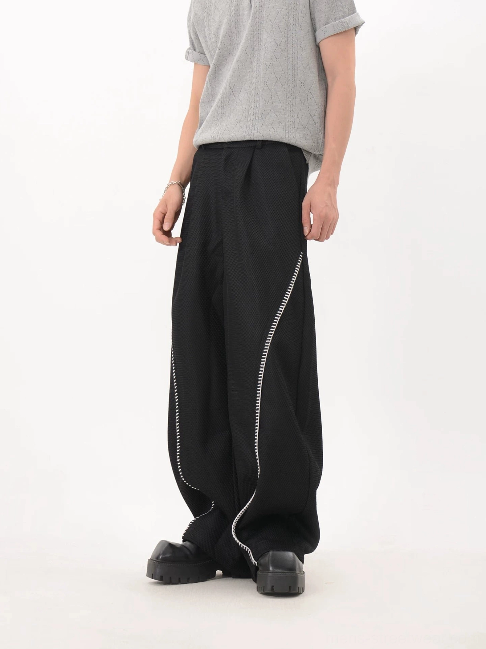 Black mesh texture wide leg techwear trousers with curved contrast piping three quarter side view