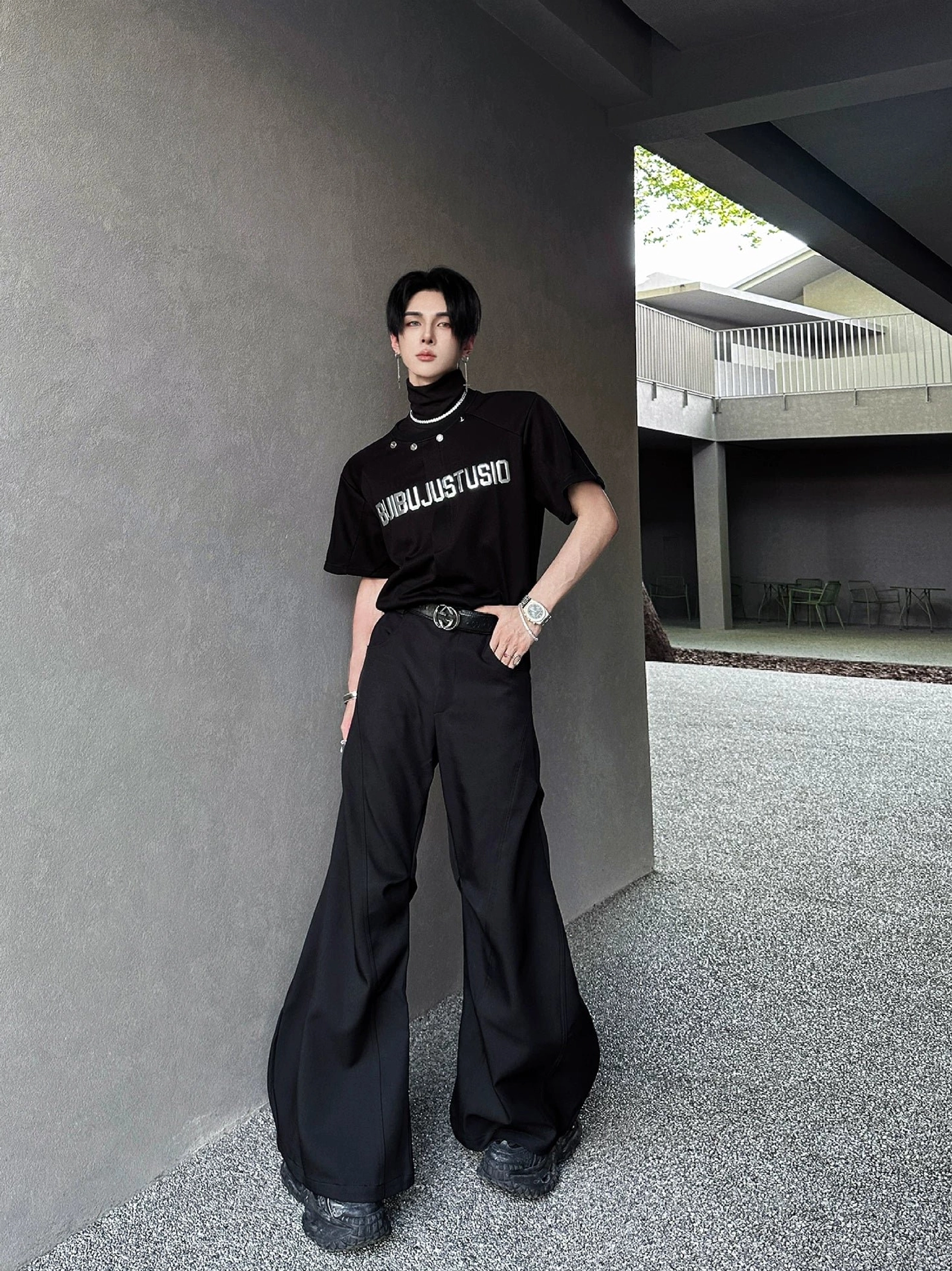Full-body model wearing a black metallic graphic tee with wide-leg trousers in a modern Seoul-inspired streetwear outfit