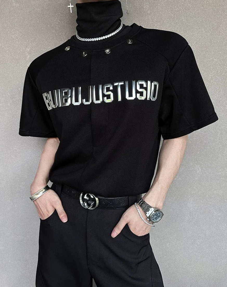 Flat mannequin display of a black metallic lettering T-shirt with industrial collar studs and leather belt styling