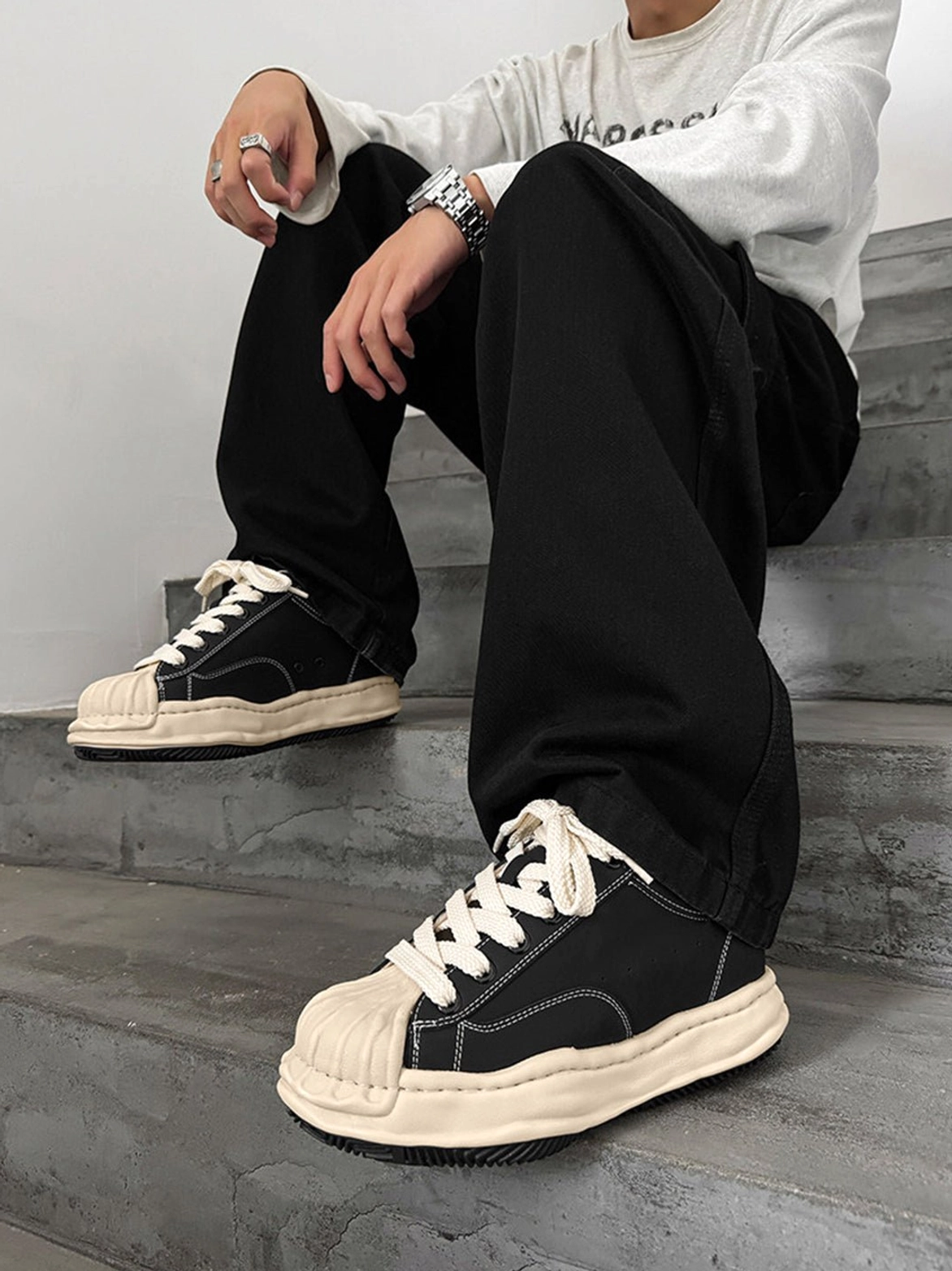 Fashion streetwear platform sneakers in black microfiber leather with cream rounded shell toe