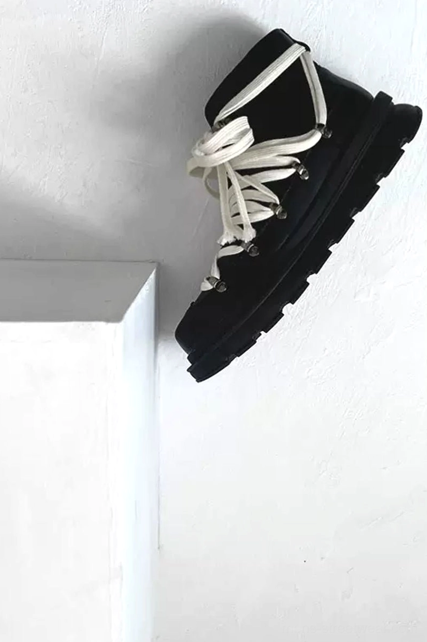 Black mid-top leather combat boot with silver metal hardware off-white laces and deep tread platform outsole