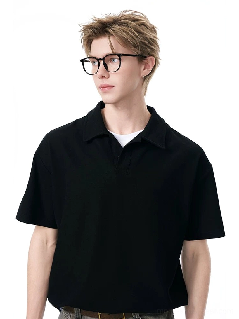 Black minimalist knit polo shirt with classic collar layered over a white T-shirt in a casual streetwear outfit