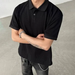 Black minimalist polo shirt with textured piqué-style fabric, classic collar, short sleeves, and button placket styled with silver bracelets for Korean streetwear