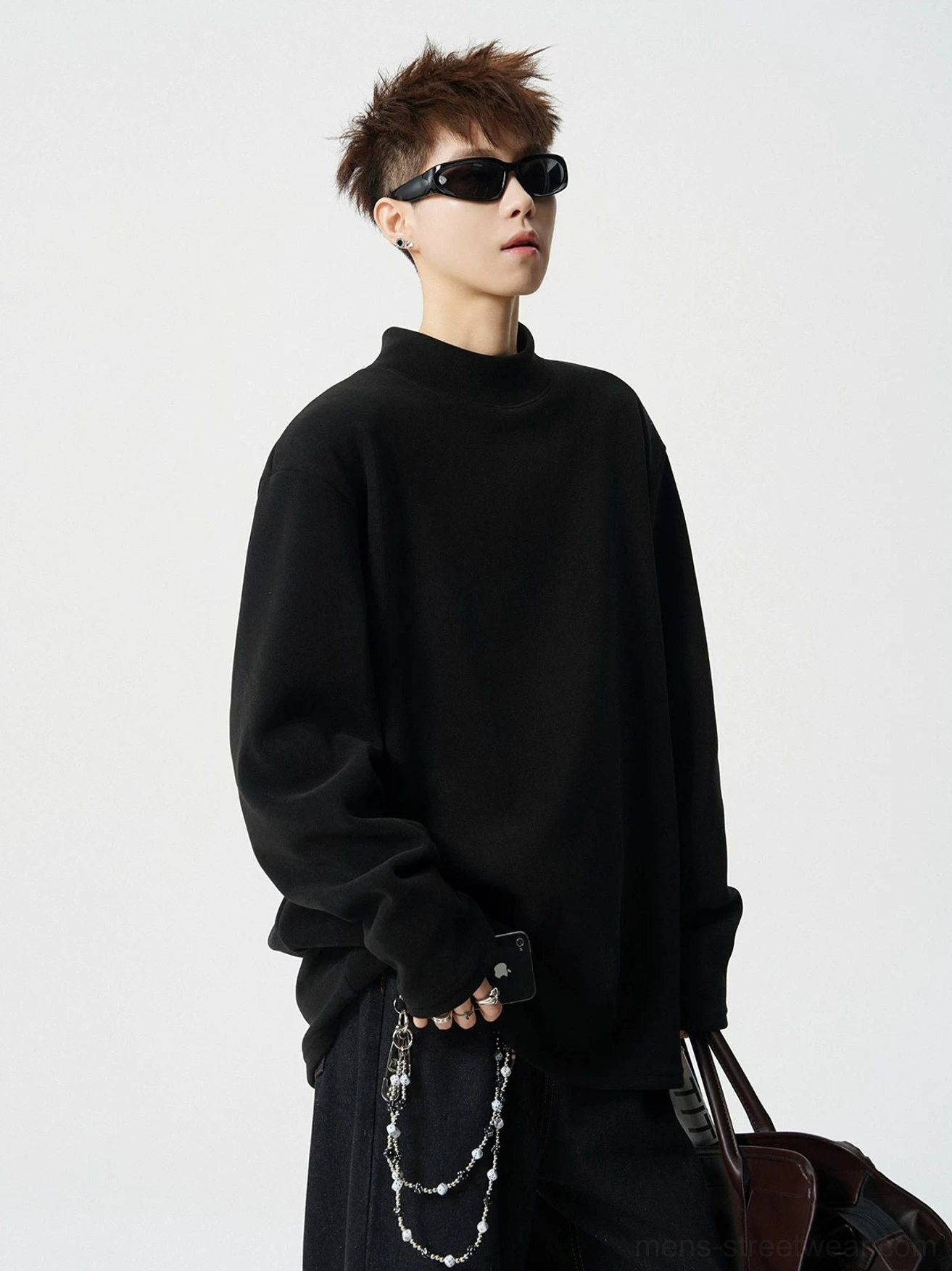 Black mock neck fleece long sleeve streetwear top shown with baggy chain trousers and leather shoulder bag