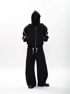 Black modular zip-up hoodie and wide-leg sweatpants set with contrast white drawcords, shown in a front full-body streetwear look