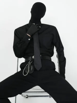 Black monochrome dress shirt and matching black tie set styled with gloves, silver crossbody chain bag, and waist chain in Korean streetwear look