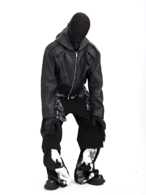 Black hooded faux leather moto jacket low-angle front view showing matte PU leather, structured torso panels, and relaxed cyber streetwear fit