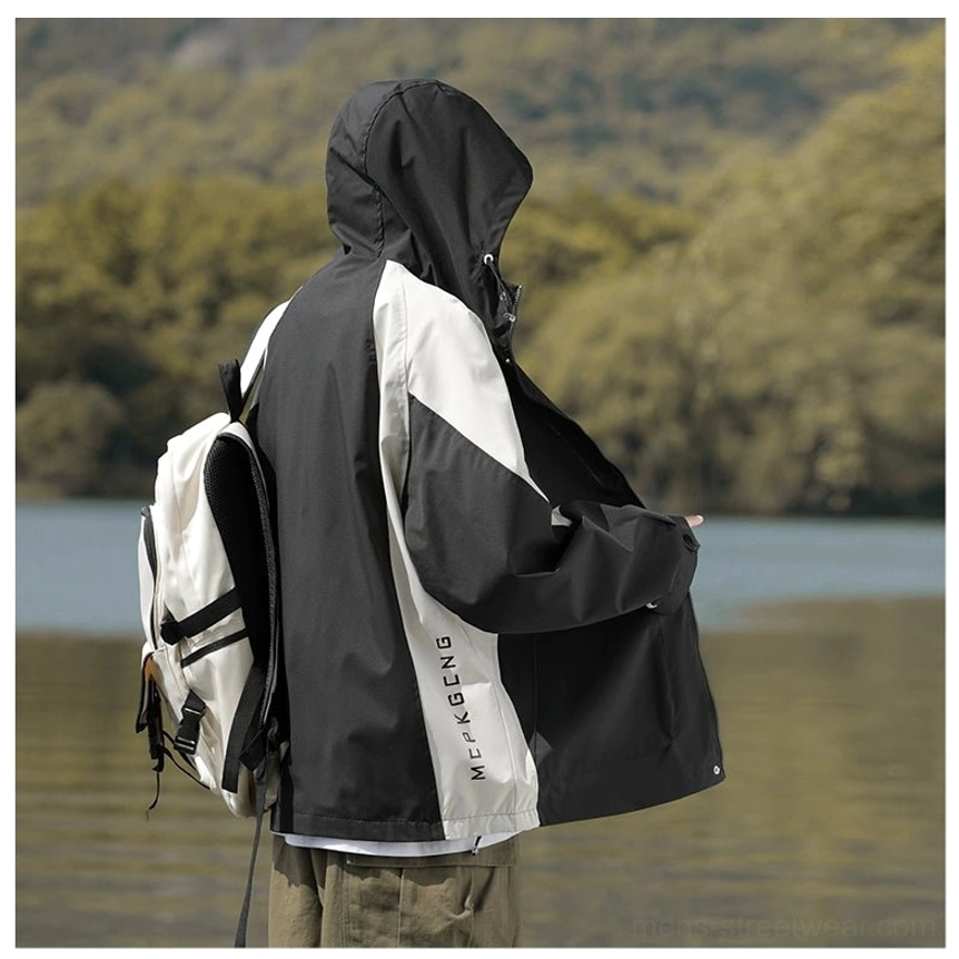 Back view of a black and off-white colorblock hooded outdoor jacket with relaxed oversized streetwear fit