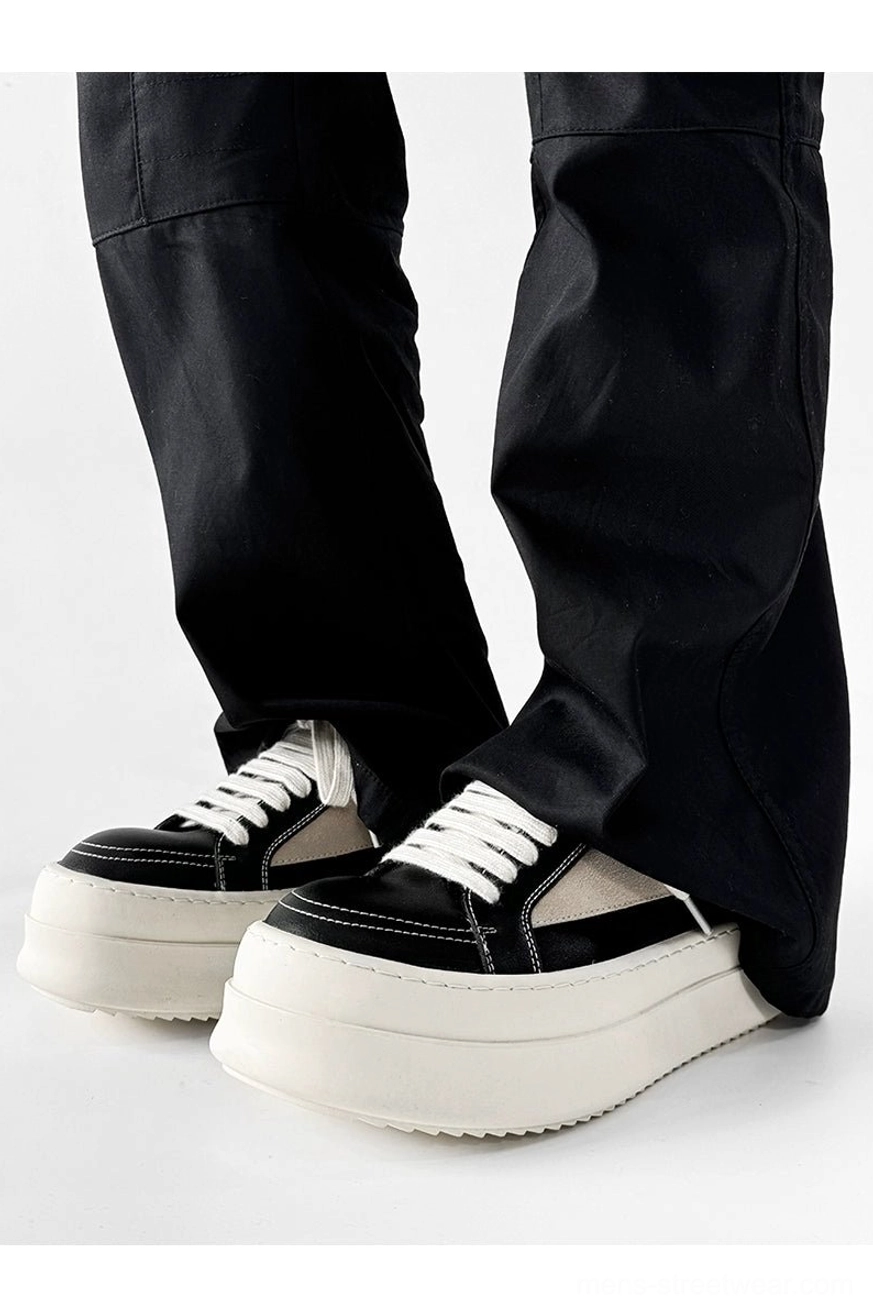 Black and off-white contrast panel platform sneakers worn with wide-leg trousers