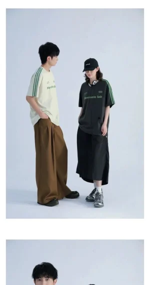 Black and off white sporty Korean streetwear T-shirts shown from the side with green contrast shoulder stripes and relaxed silhouettes