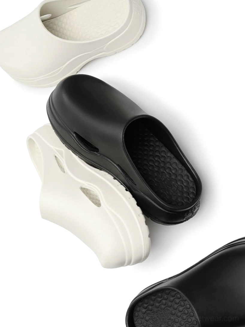 Black and off-white slip-on platform clogs displayed together with chunky layered soles, side cutouts, and honeycomb insoles