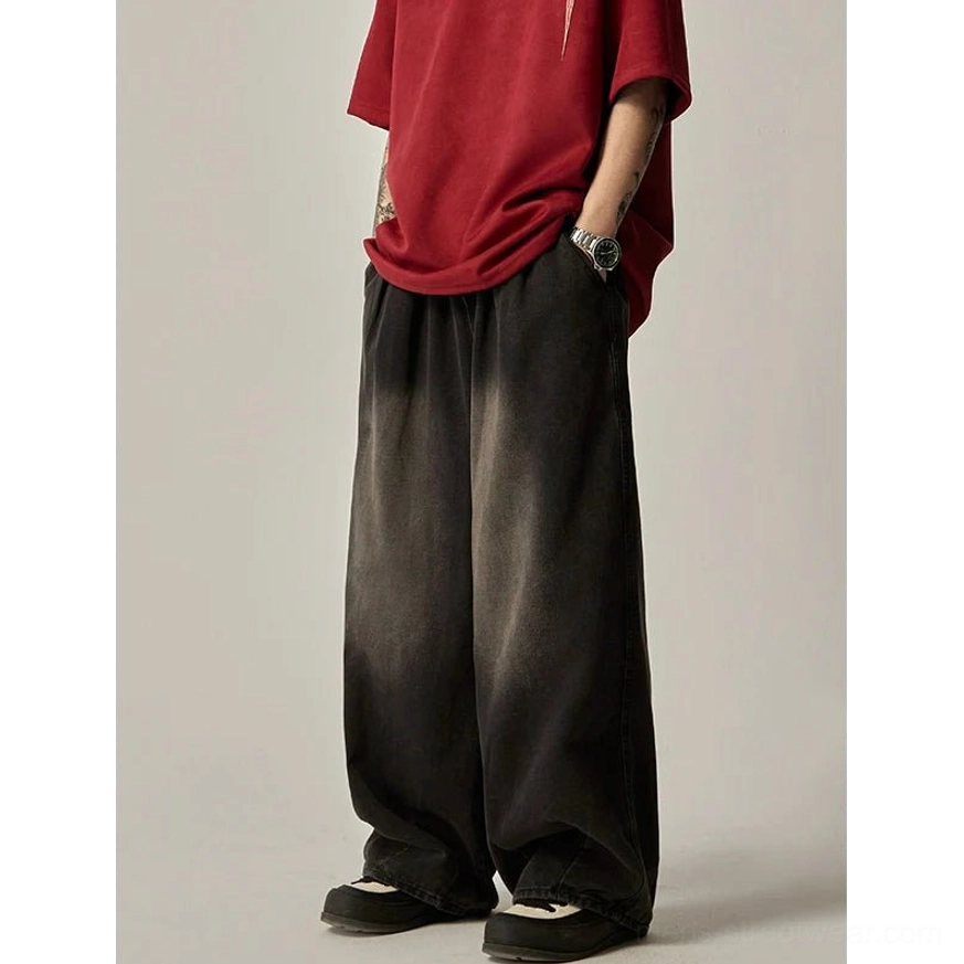 Side view of black ombre washed wide-leg jeans with raw frayed hem and loose skatewear-inspired fit