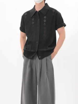 Black openwork argyle knit polo cardigan worn with gray wide-leg trousers in a front three-quarter streetwear look