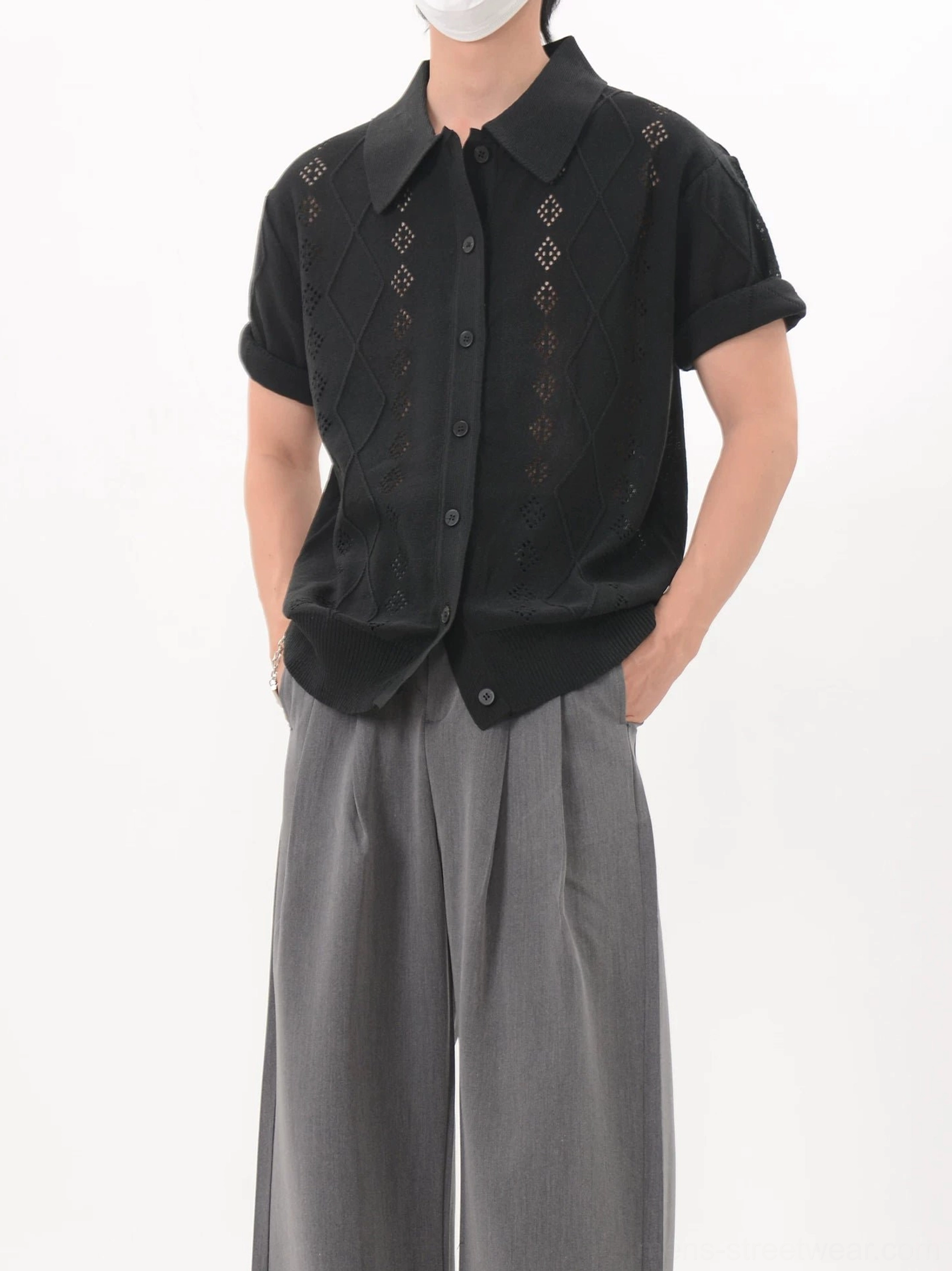Black openwork argyle knit polo cardigan worn with gray wide-leg trousers in a front three-quarter streetwear look
