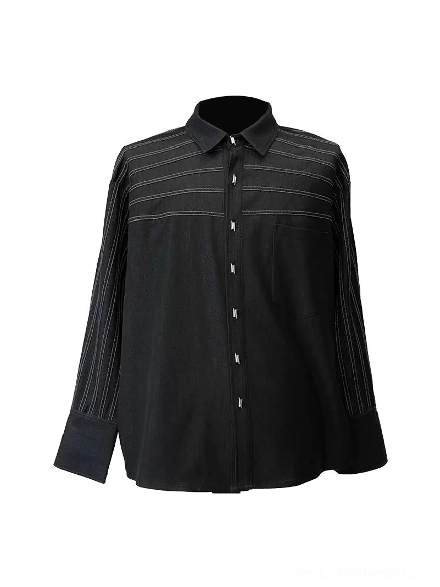 Flat lay front display of black oversized button shirt with contrast horizontal stitching, chest patch pocket, and pleated sleeves