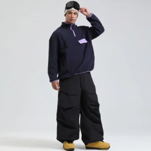Black oversized cargo snow pants with multiple utility pockets and elastic gaiter cuffs styled for snowboard streetwear