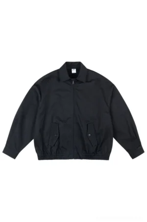 Black oversized cotton work jacket with pointed collar front zipper buttoned flap pockets and elasticated hem