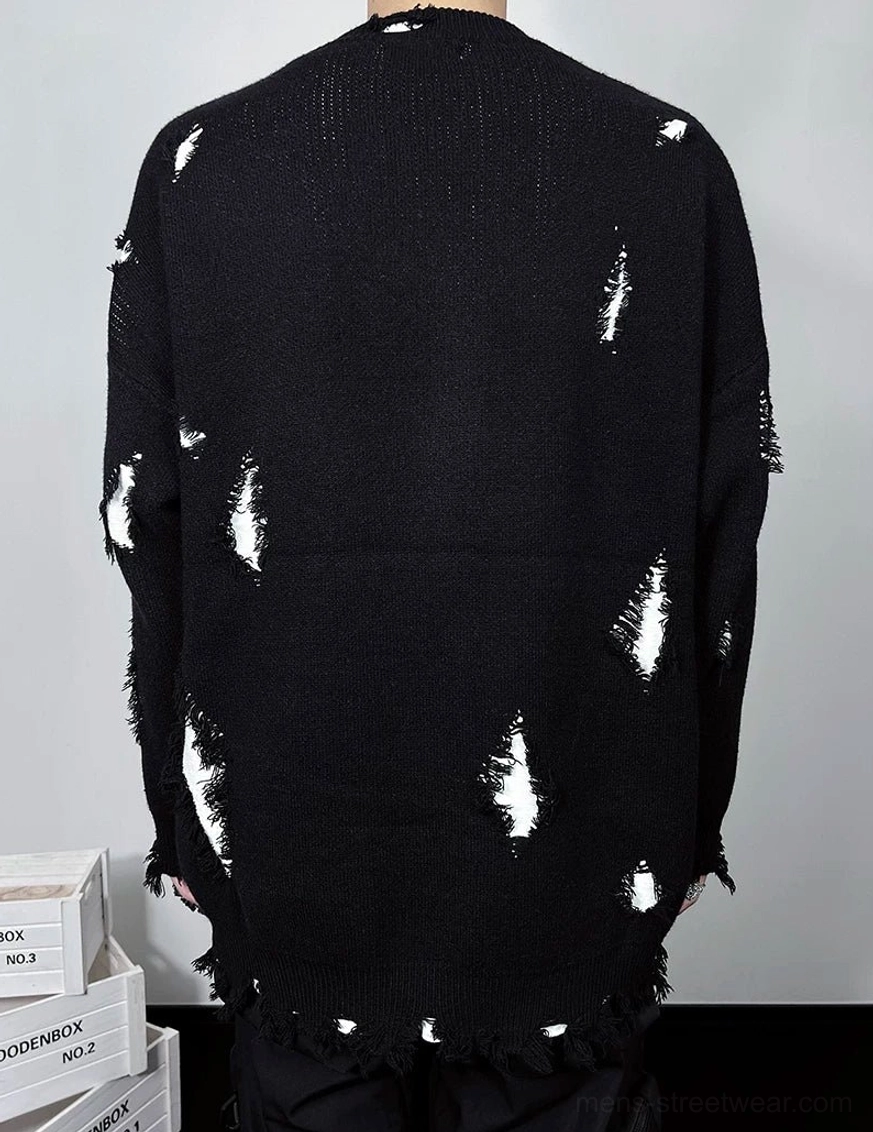 Flat lay back view of a black distressed oversized crewneck sweater with white inner neckline trim, shredded knit accents, and raw frayed hem