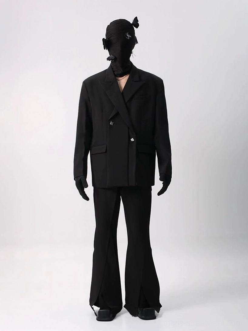 Black oversized double-breasted blazer and matching flared suit trousers shown in a full-body front view with notched lapel, flat pockets, and ankle slit details