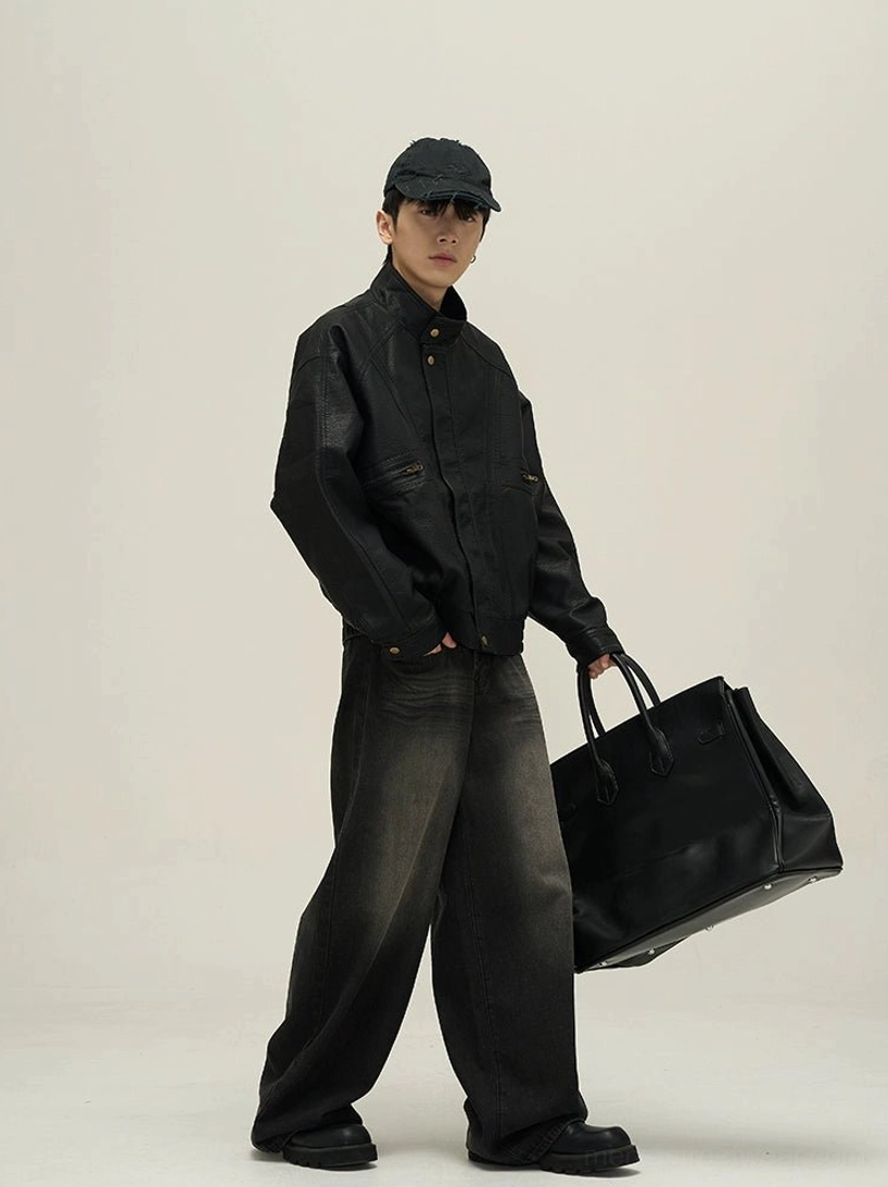 Black oversized faux leather stand collar bomber jacket side view styled with washed wide-leg denim and tote bag