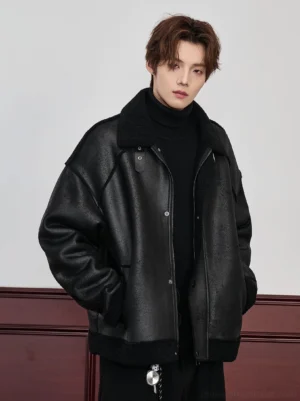 Black oversized faux shearling aviator bomber jacket for men shown in a front three-quarter view with matte faux leather look shell, black shearling collar, and snap-button closure