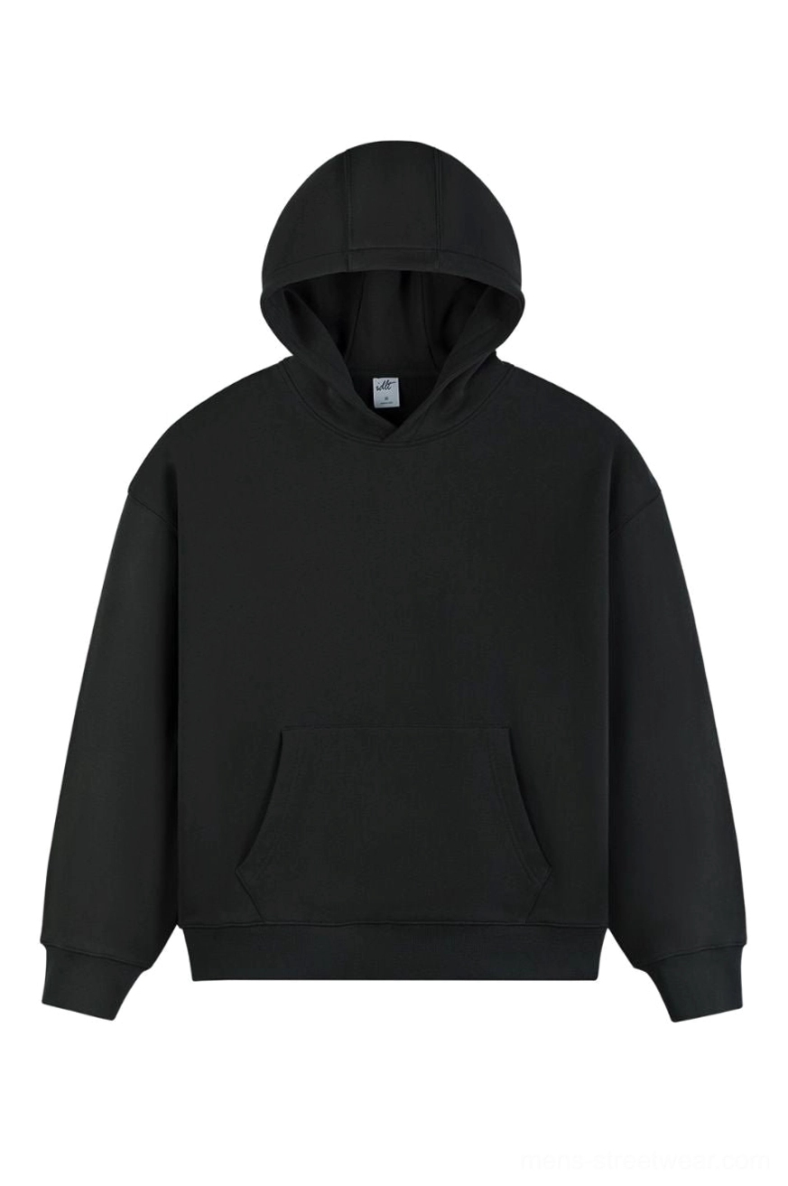 Black oversized heavyweight cotton pullover hoodie with dropped shoulders front kangaroo pocket and attached hood on white studio background