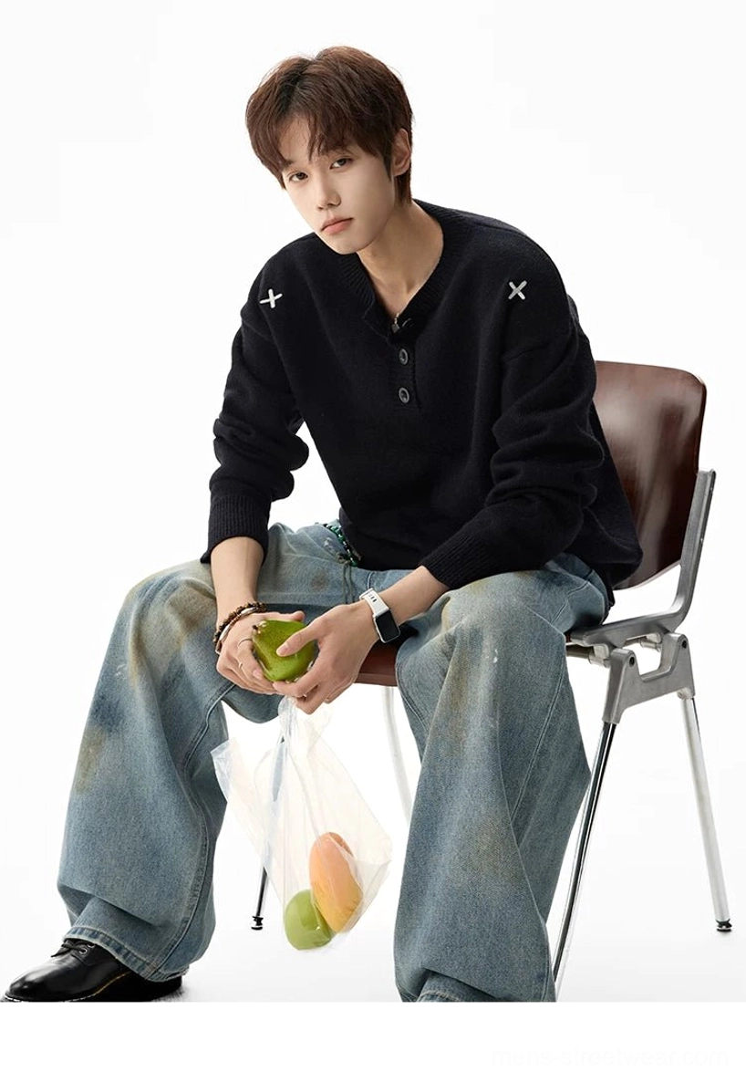 Black oversized henley knit sweater with cross embroidery on both shoulders styled with vintage washed baggy jeans