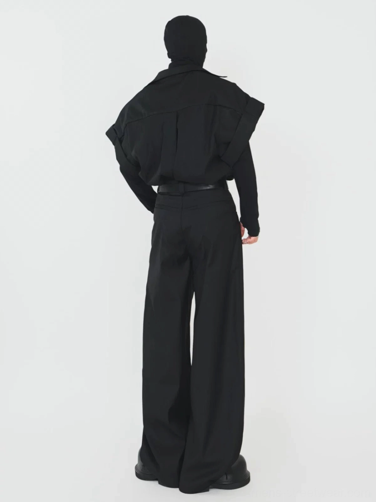 Rear view of an all black oversized layered shirt outfit with pleated back detail and high waisted wide leg trousers