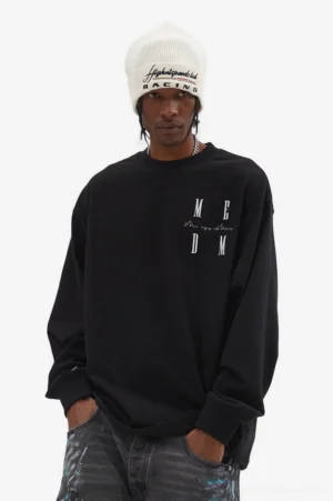 Black oversized graphic long sleeve T-shirt with chest MCDM lettering styled with dark patterned jeans and a knit beanie