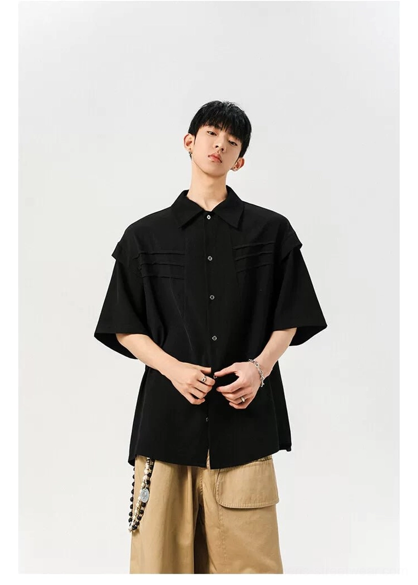 Black oversized minimalist streetwear button shirt shown from the front with polished metal buttons and relaxed proportions