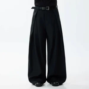 Black oversized wide-leg trousers with deep front pleats, high waist, integrated belt, and flowing streetwear silhouette worn by a male model