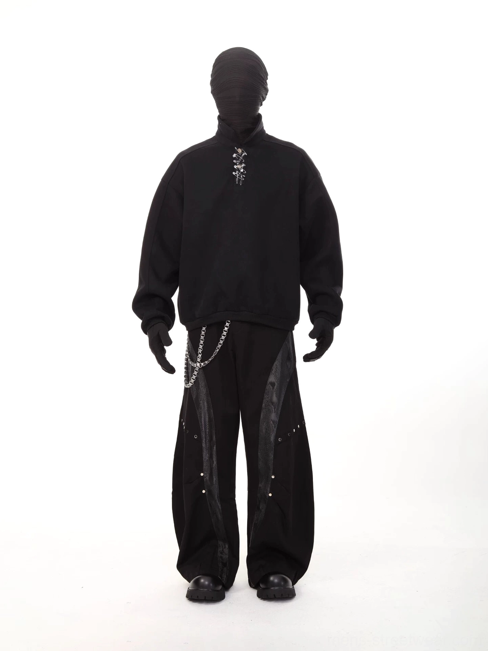 Black oversized polo collar sweatshirt front view with metal neckline detail styled with wide leg pants and chain accessories