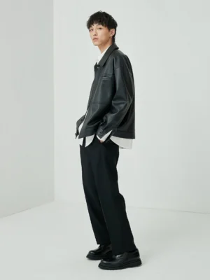 Black oversized cropped PU leather jacket side full-body view male model casual minimalist fit check hands in pocket