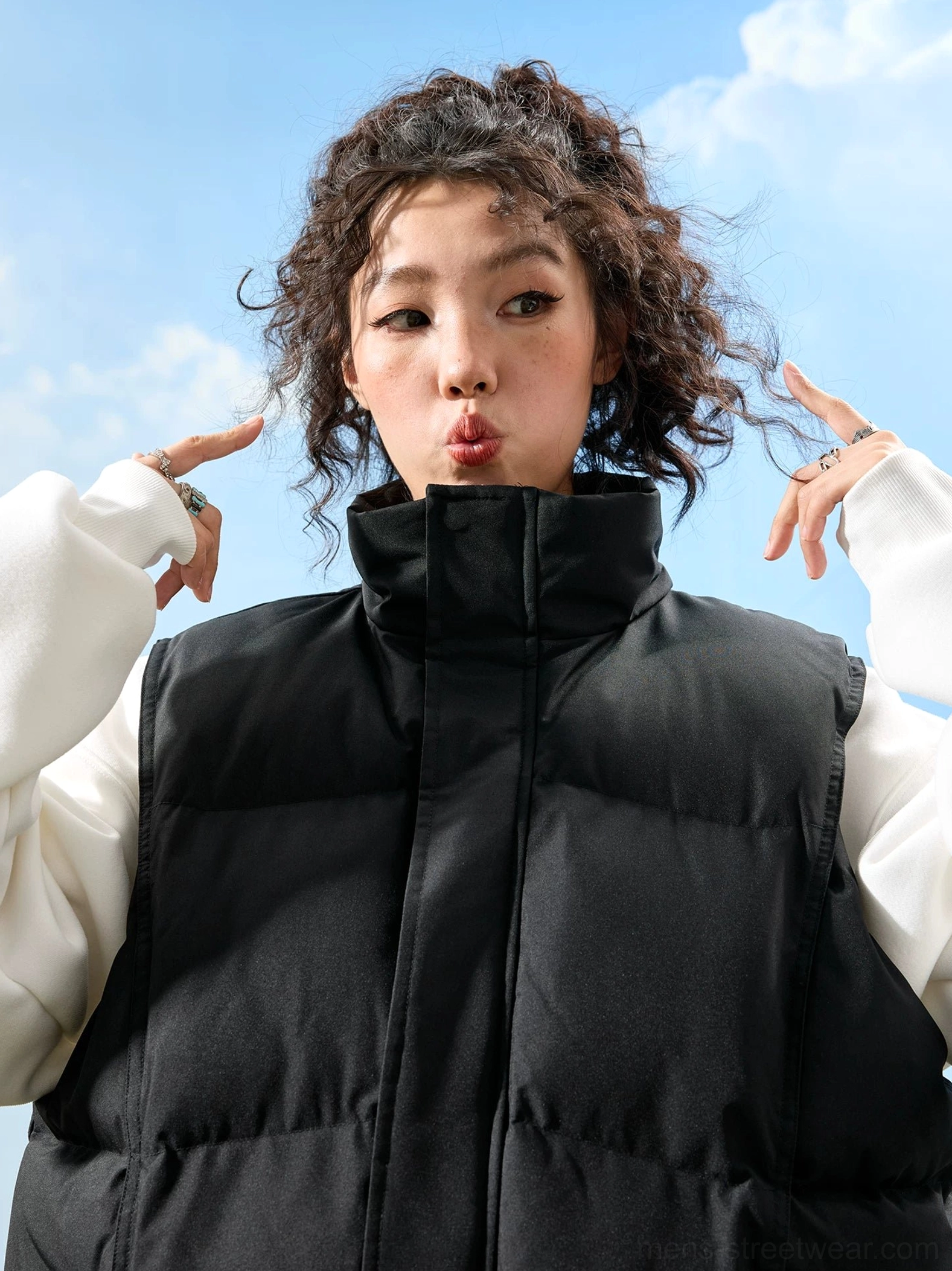 Black oversized puffer vest with high stand collar, neat channel quilting, sleeveless streetwear design, and front zipper