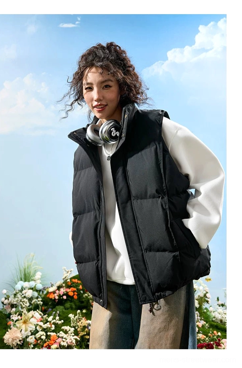 Black oversized quilted puffer vest shown from the side with channel stitching, front zipper, and relaxed sleeveless silhouette