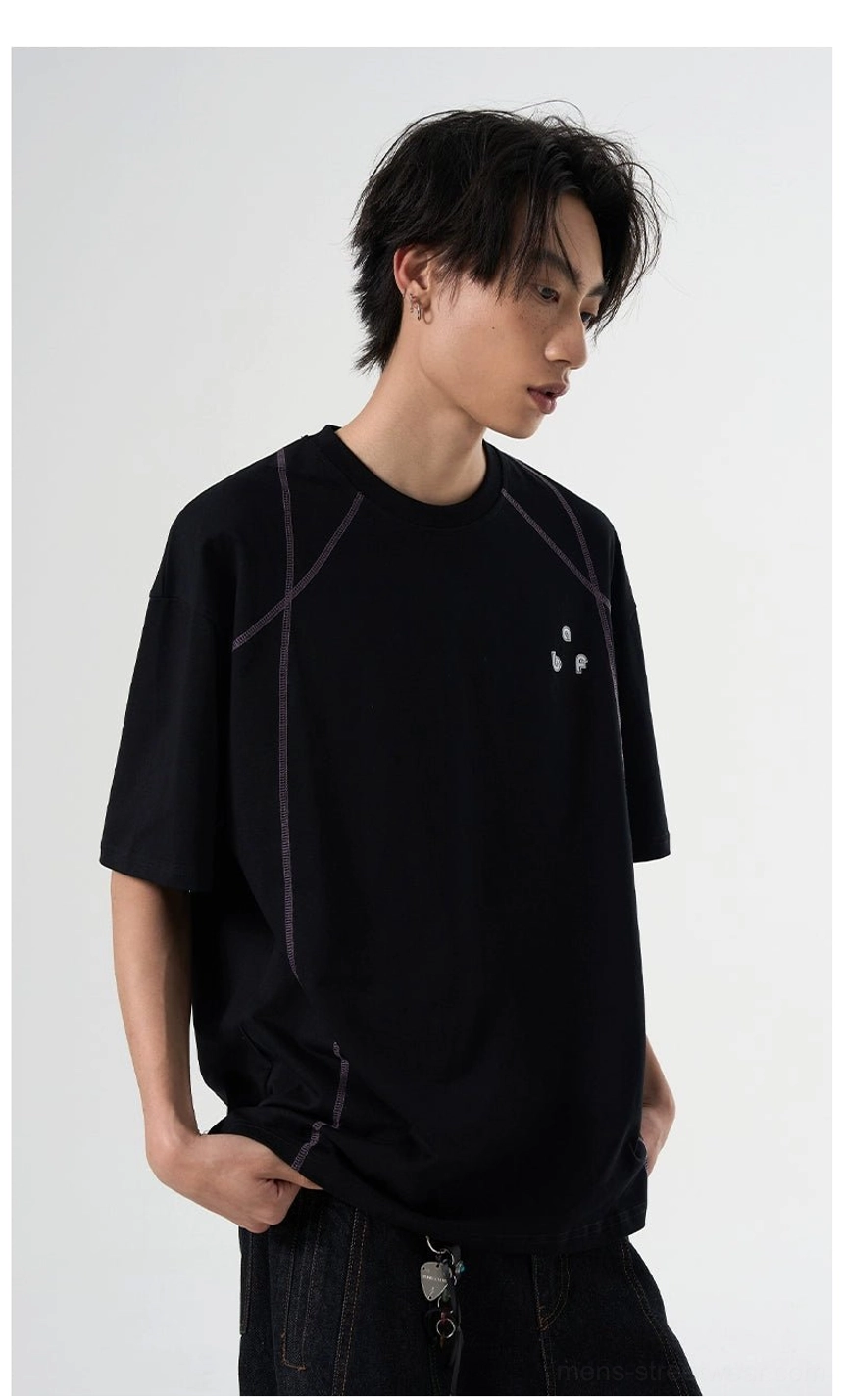 Black oversized relaxed T-shirt with contrast seam lines and small chest graphic shown from the side