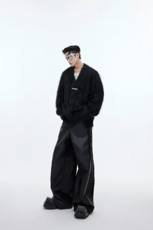 Side view of black oversized shaggy faux-fur V-neck sweater with relaxed silhouette, ribbed neckline, and layered streetwear styling