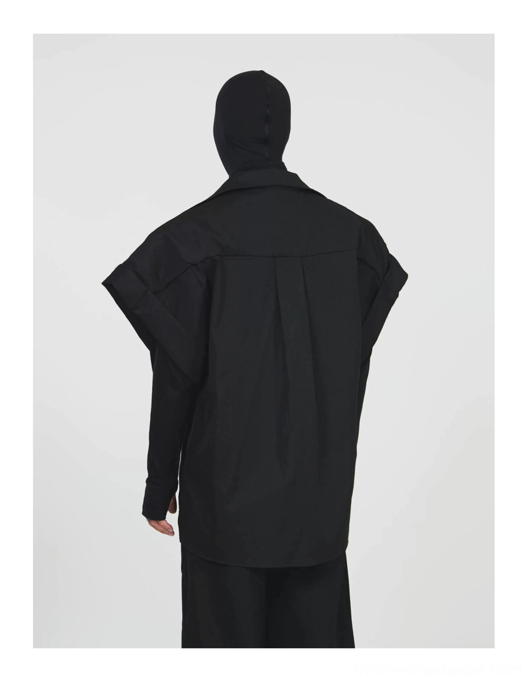 Rear view showing the oversized black shirt jacket silhouette, structured shoulder seams, and exposed back yoke