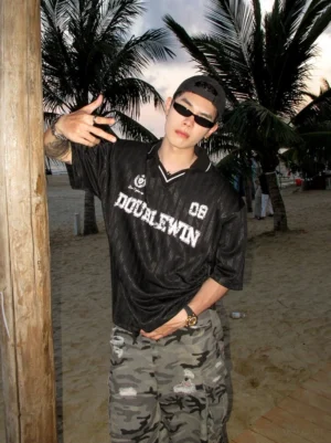 Three-quarter view of a black oversized sports mesh jersey tee featuring vertical striped fabric, chest badge, distressed 08 lettering, and relaxed Korean streetwear fit