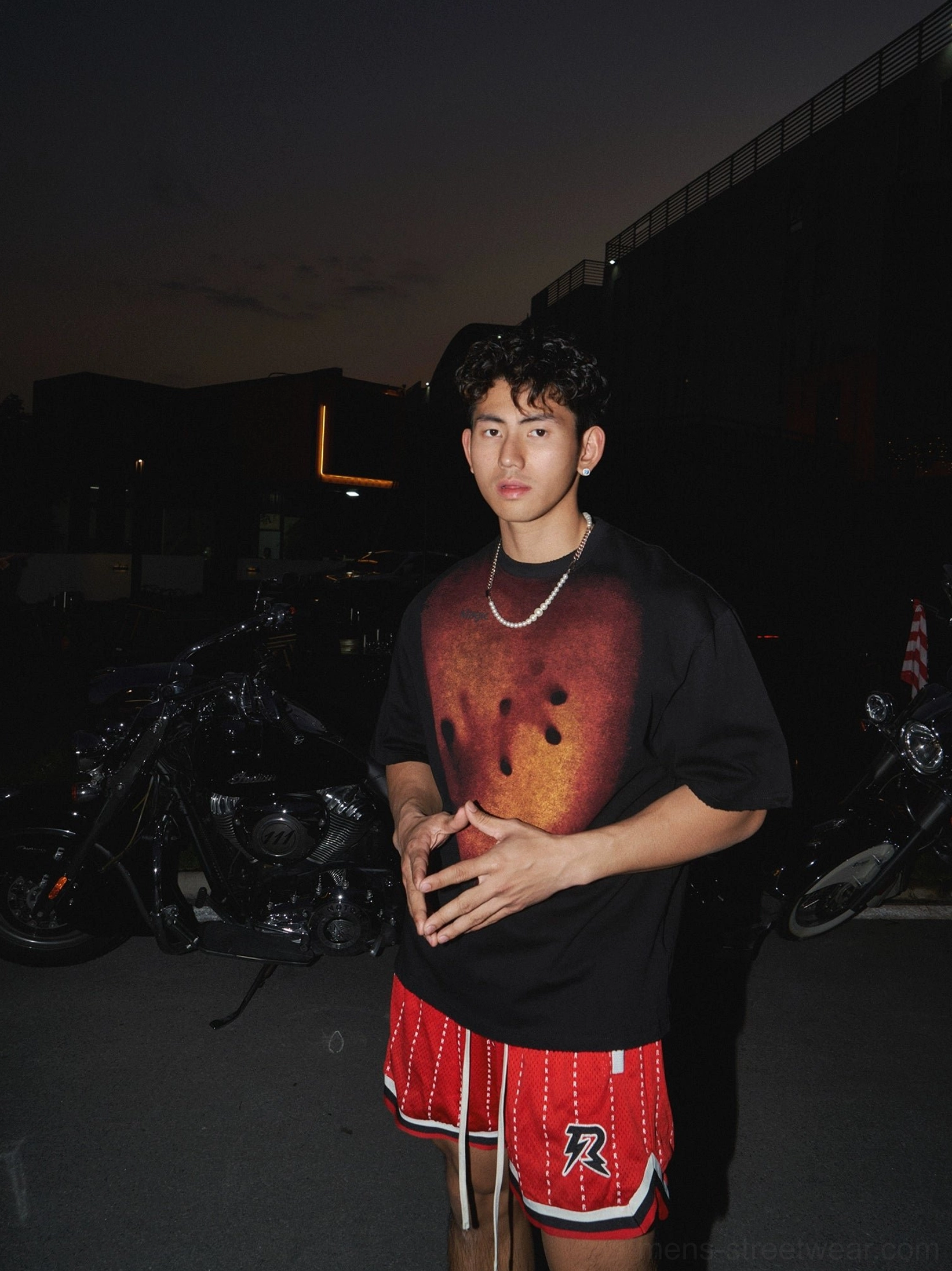 Black oversized graphic streetwear T-shirt with burnt orange handprint chest artwork styled with a silver Cuban chain