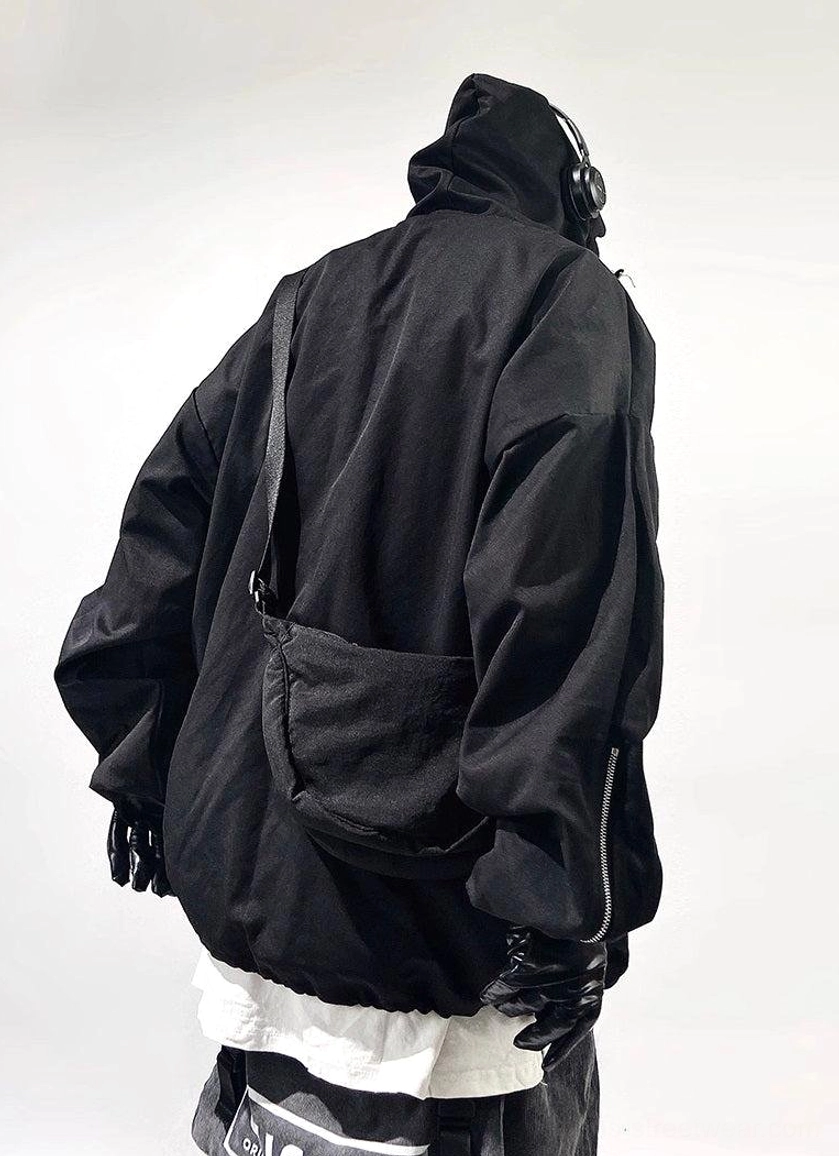 Rear view of black oversized tactical streetwear jacket with attached hood, crossbody bag styling, rear drawcord hem, and sleeve zippers