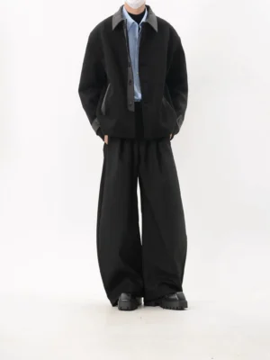 Back view of a black oversized textured streetwear jacket showing the relaxed boxy silhouette, dropped shoulders, long sleeves, and clean minimal back design